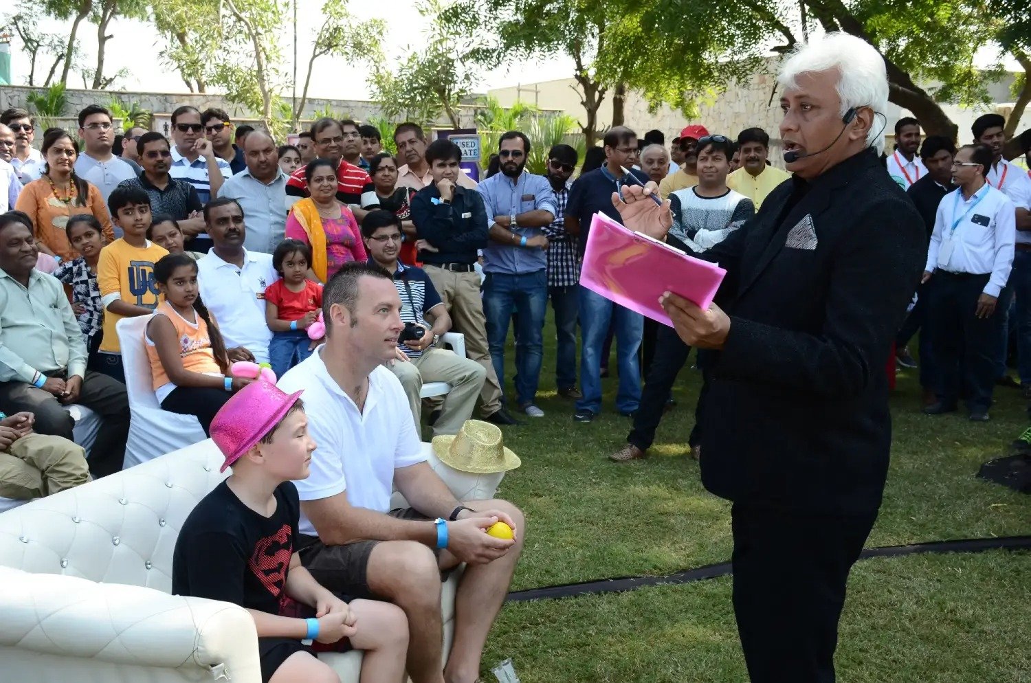 Men lighting ceremonial lamp at event with ITT banner in background